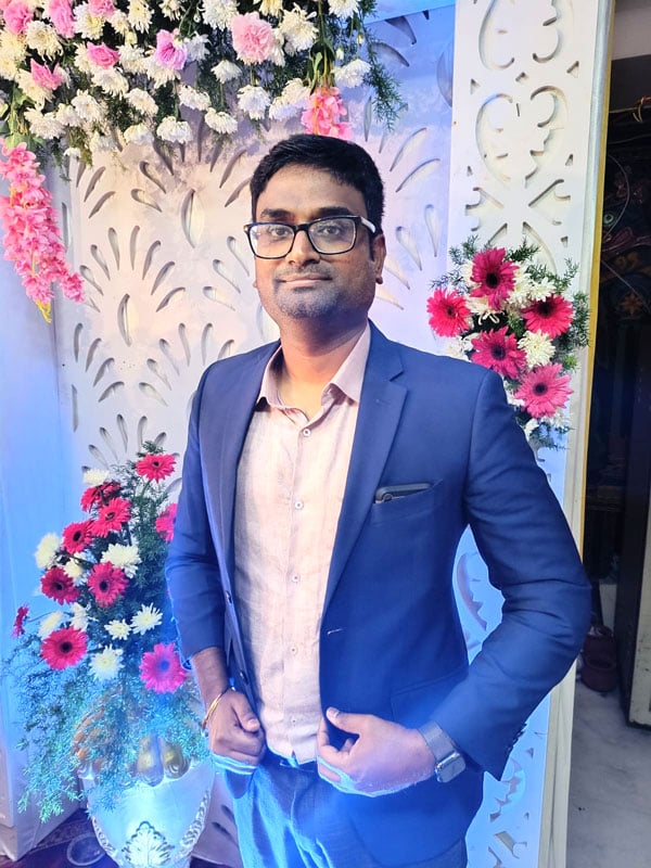 Headshot of Data Engineer Vinoth Nageshwaran wearing a blue suit